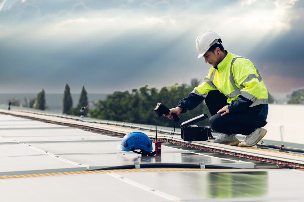 Inspector examination of photovoltaic modules using a thermal imaging camera.